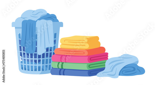 A blue laundry basket full of clothes sits next to a stack of colorful folded towels and a single unfolded blue towel.
