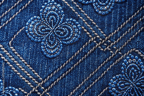 Wallpaper Mural Textured Denim Elegance: Intricate floral embroidery and geometric stitching adorn a denim fabric, creating a sophisticated and detailed pattern. Torontodigital.ca