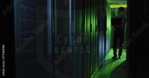 Korean technician configuring server racks with laptop in green LED corridor, copy space