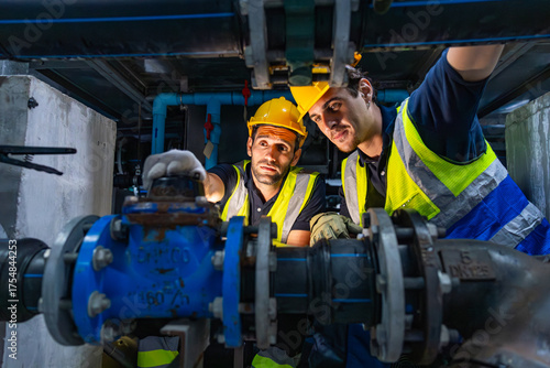 Engineers inspecting industrial pipeline system underground