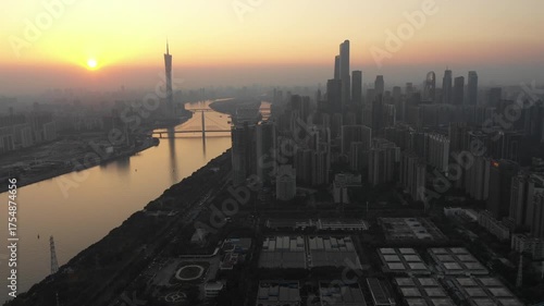 Retreating drone shot of modern Guangzhou skyline at sunset
