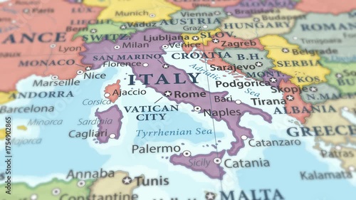 4K macro video of Italy on a world map with shallow depth of field. Focus on word Italy and surrounding areas including France, Switzerland, Austria, and the Mediterranean Sea. Travel footage