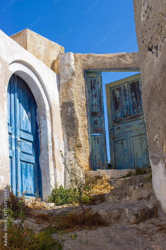 Fototapeta premium old door of white house in Magalochori town on Santorini island, Greece