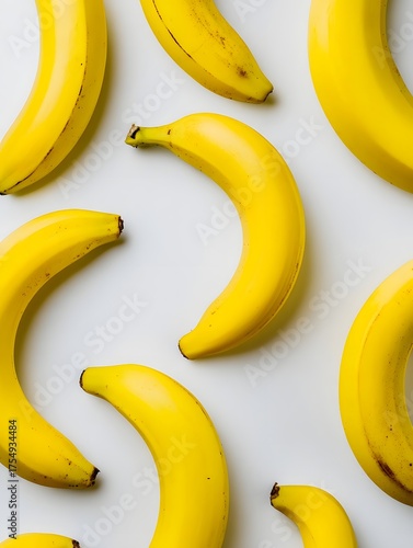 A minimalist pattern of yellow bananas uniformly arranged in simple lines from a top down view on a white surface with soft shadows