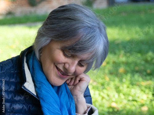 Billede på lærred Joyful senior woman with gray hair and a blue scarf smiles with her eyes closed