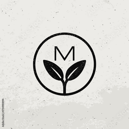 M above sprouting leaves encased in a circle, on a beige, speckled background