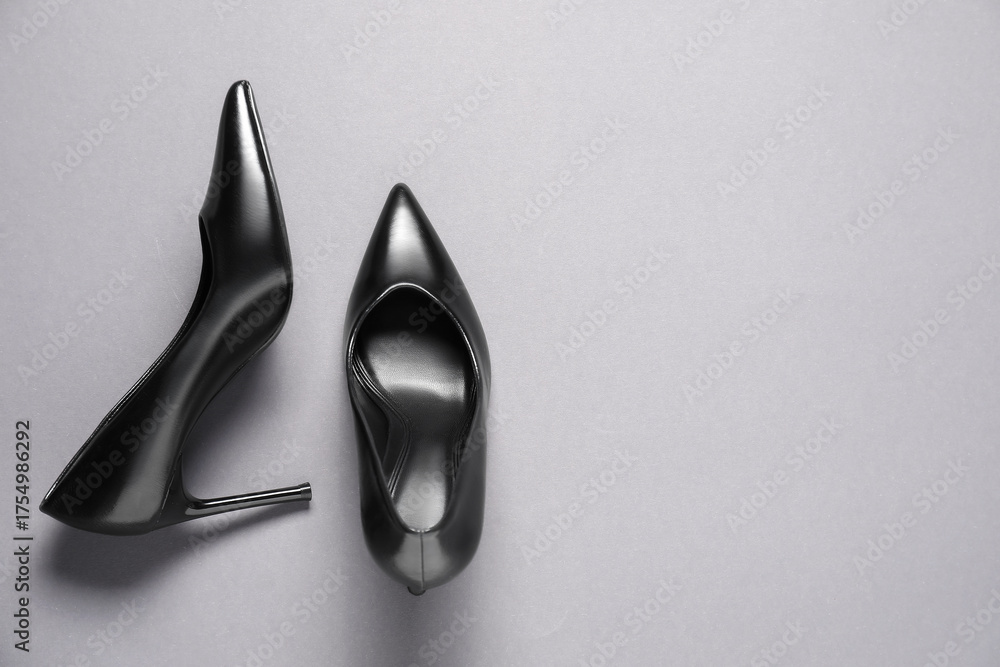 Fototapeta premium Pair of elegant black heels on light grey background, top view with space for text. Stylish shoes