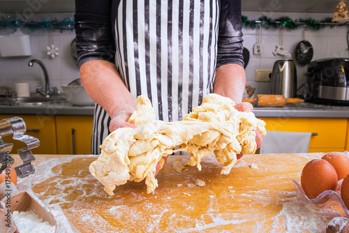 Bad dough. Inexperienced unskillful woman cook in an apron holds unsuccessful sticky dough in her hands. Сoncept of bad cooking