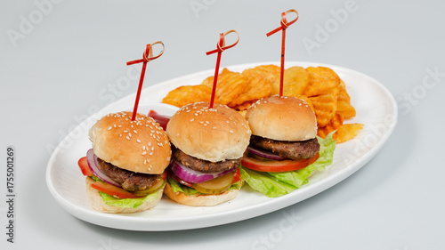 Three burgers and fries on tray