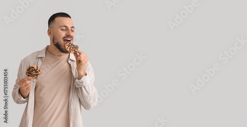 Young man eating cookies on...
