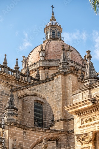 The dome and statues of Jerez Cathedral in Cadiz, Spain, illuminated by sunlight against a clear blue sky