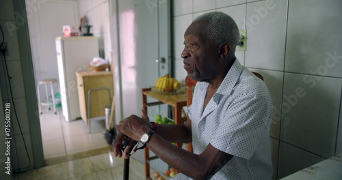 Φωτογραφία African American Elderly man seated in quiet reflection, holding a cane, exuding