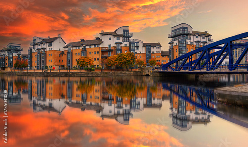 Water of Leith landscape at sunset in the north of Edinburgh, Scotland, United Kingdom, tranquil reflections of buildings, houses, and the landmark Victoria Swing Bridge on the calm port.