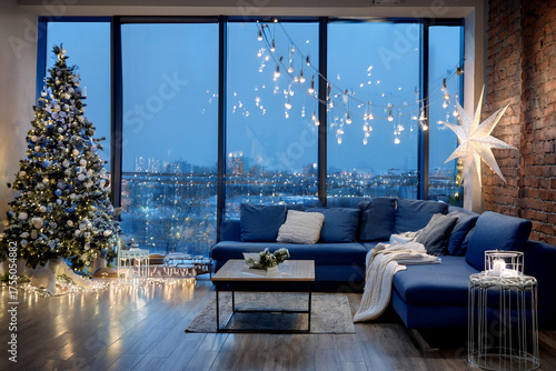 A stylish modern loft decorated for Christmas: app-controlled LED string lights, personalized wooden ornaments engraved with names, minimalist Scandinavian furniture in cool tones, and large windows