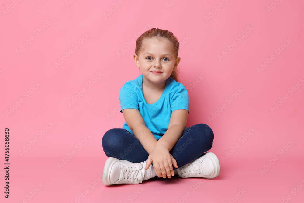 Naklejka premium Cute little girl posing on pink background