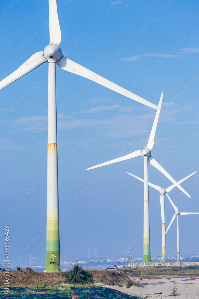 Fototapeta premium White wind turbines stand on the coast