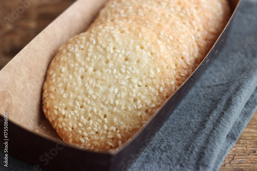 Sesame cookies in a box on a wooden table