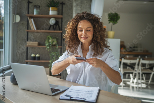 Foto Woman scanning documents with smart phone for home office work