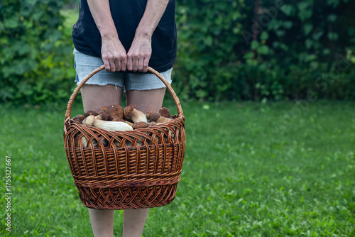 Cute girl holding a basket of porcini mushrooms