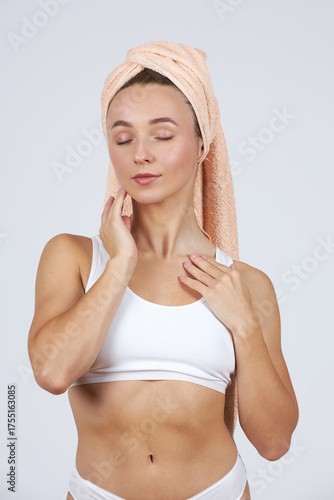A young beautiful girl in white lingerie with a towel on her head does cosmetic procedures.