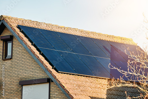 Residential house with solar panels on roof close-up. Solar panels mounted on a tiled roof. Solar energy 