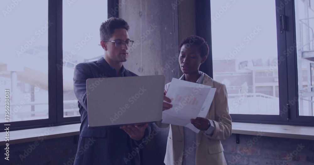 Fototapeta premium Reviewing data, man in suit and woman in blazer at contemporary office, with laptop, chart sheet
