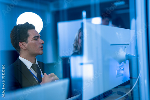 Foto In a futuristic high-security office, a corporate intelligence analyst conducts a covert digital forensics investigation, tracking the source of a sophisticated industrial espionage attempt