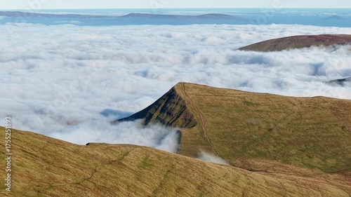 Majestic mountain landscape with peaks rising above a sea of clouds in Brecon Beacons