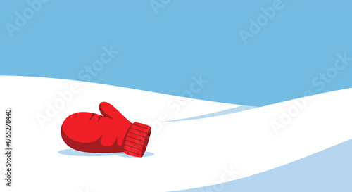 Lost red mitten lies alone on a snowy hill under a bright blue sky, suggesting a feeling of coldness and isolation in the winter landscape.