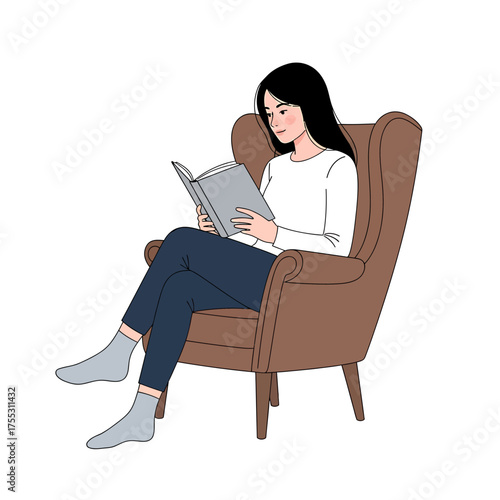 A woman is comfortably seated, engrossed in reading a book while relaxing in an armchair.