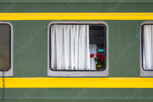 Green Train Carriage Window With White Curtains And Red Roses Inside
