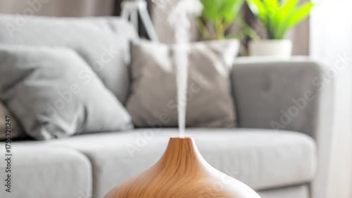 Wooden essential oil diffuser emitting fragrant vapor in a soft-focus, minimalist living room with cushions
