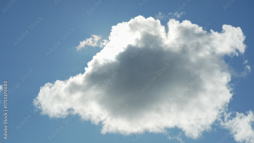 Fototapeta premium “Dramatic fluffy cloud in blue sky with sunlight behind”