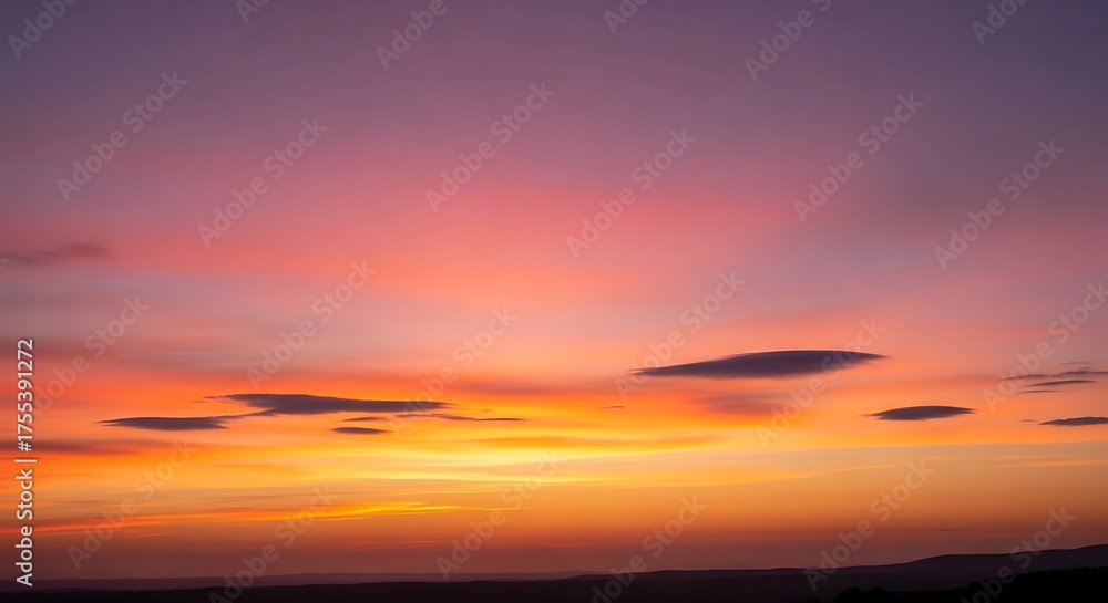 Fototapeta premium Pink and orange sunset sky with soft clouds over calm horizon