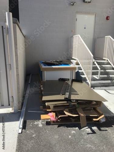 Bunch of Junk Piled Up Outside of Building by Stairs 