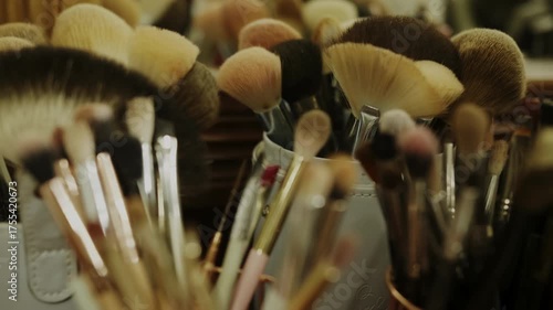 A dense collection of professional makeup brushes, featuring soft bristles in various shapes and sizes, is revealed as the camera slowly pulls back, showcasing the essential tools for cosmetic applica