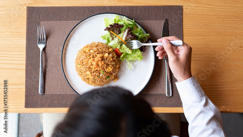 Person eating fried rice with salad