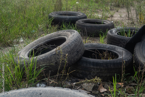 Illegal dumping of used rubber tires in a field, an environmental problem.