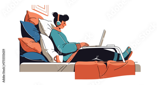 Young woman wearing headphones working on a laptop while relaxing on a couch.