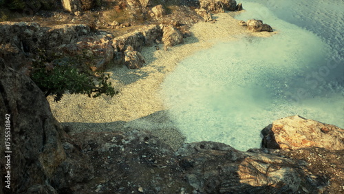Fotografía Soft waves lap against the pebbly shore as daylight fades