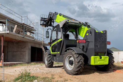 Forklift on a construction site, preparing to raise construction parts
