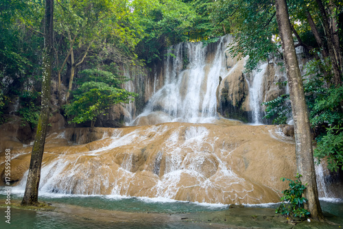 Sai Yok Noi Waterfall in Kanchanaburi, Thailand, is a charming spot surrounded by lush forest, a gentle cascade, peaceful nature, and beautiful scenery.