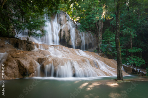 Sai Yok Noi Waterfall in Kanchanaburi, Thailand, is a charming spot surrounded by lush forest, a gentle cascade, peaceful nature, and beautiful scenery.