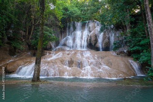 Sai Yok Noi Waterfall in Kanchanaburi, Thailand, is a charming spot surrounded by lush forest, a gentle cascade, peaceful nature, and beautiful scenery.