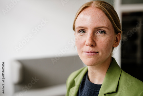 Portrait of a woman in green jacket in loft with copy space