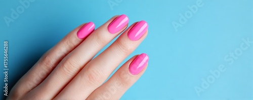 Glossy Pink Manicure on Hand Against Light Blue Background