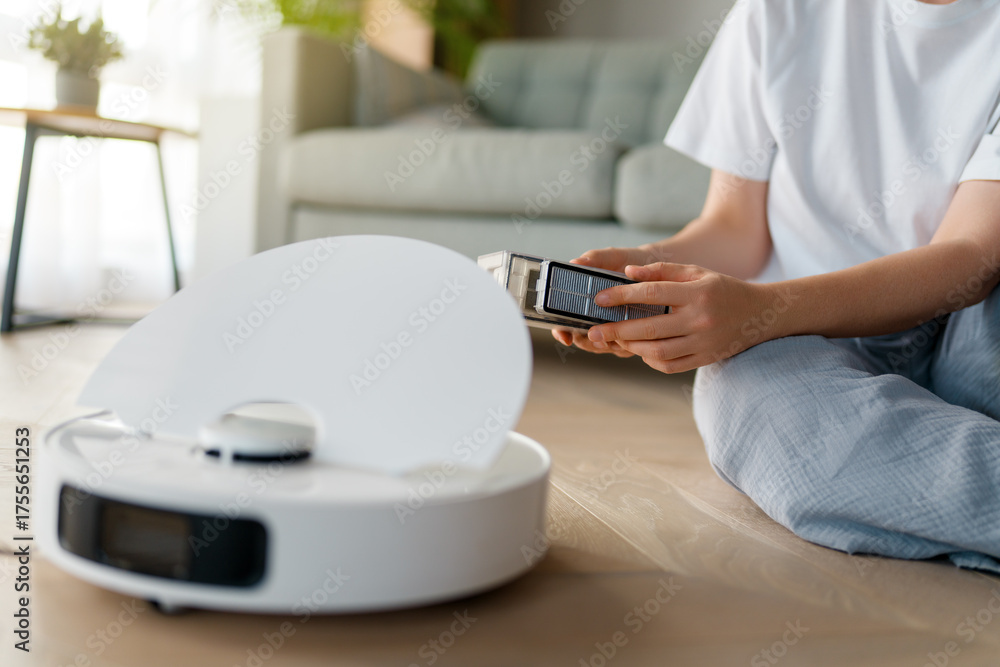Fototapeta premium White robotic vacuum cleaner on wooden floor