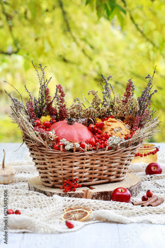 Foto Florist at work: woman shows how to make seasonal autumn table decoration with pumpkins, flowers and plants in a wicker basket