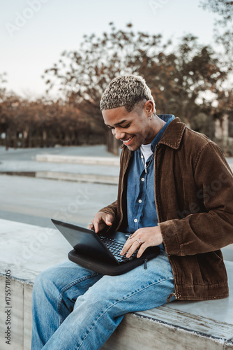 Young Latin American working with a laptop in a park