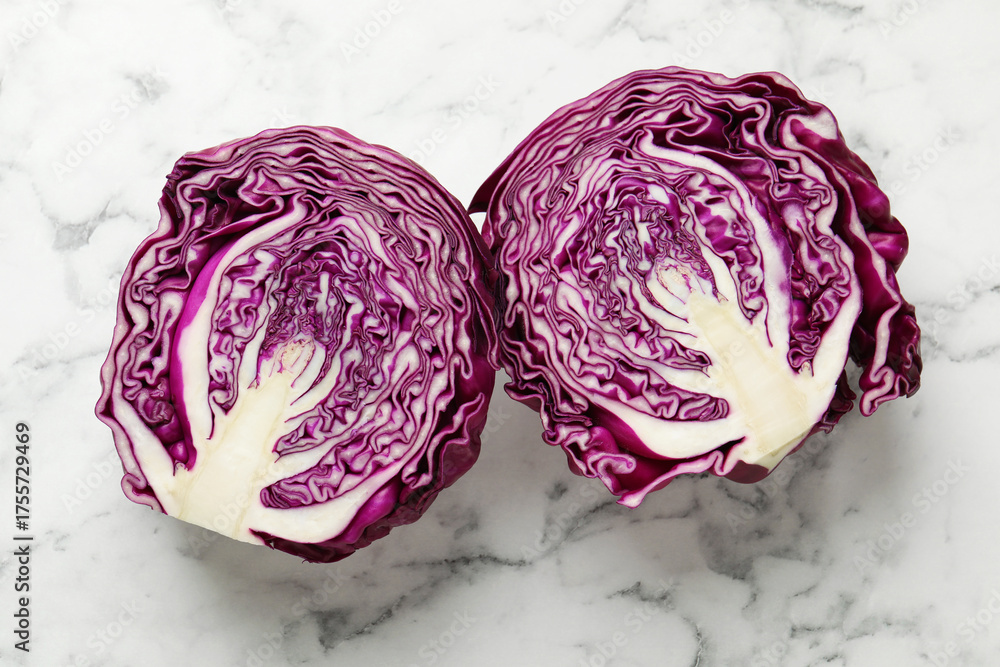 Obraz premium Cut red cabbage on white marble table, top view